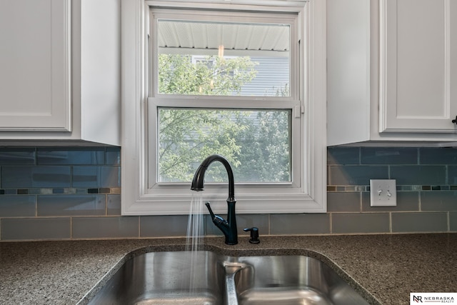 2000 Murray Rd, Plattsmouth, NE 68048 - kitchen view of a sink, white cabinets, dark stone counters, and tasteful backsplash
