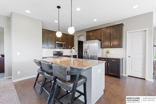 20904 Camden Ave, Omaha, NE 68022 - kitchen with stainless steel appliances, dark brown cabinetry, a sink, dark wood-style flooring, and recessed lighting