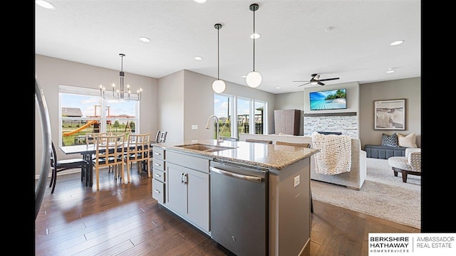 20904 Camden Ave, Omaha, NE 68022 - kitchen featuring stainless steel dishwasher, a sink, a stone fireplace, ceiling fan, and healthy amount of natural light