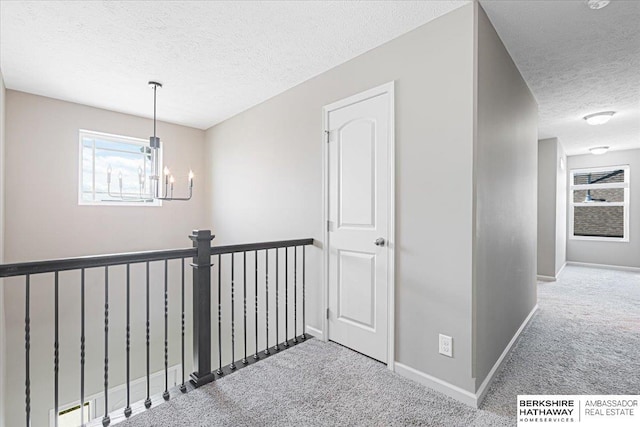 20904 Camden Ave, Omaha, NE 68022 - corridor with carpet floors, a textured ceiling, healthy amount of natural light, a chandelier, and baseboards