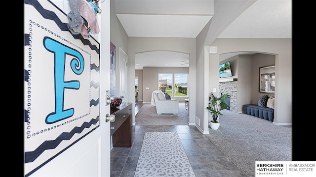 20904 Camden Ave, Omaha, NE 68022 - foyer with dark colored carpet, arched walkways, and baseboards