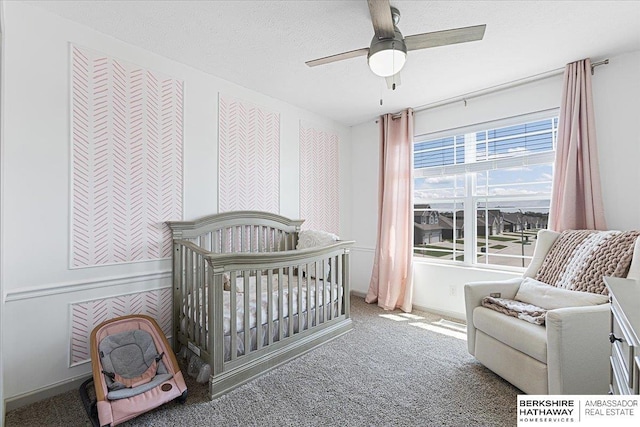 20904 Camden Ave, Omaha, NE 68022 - bedroom with carpet flooring, a nursery area, baseboards, a ceiling fan, and a textured ceiling
