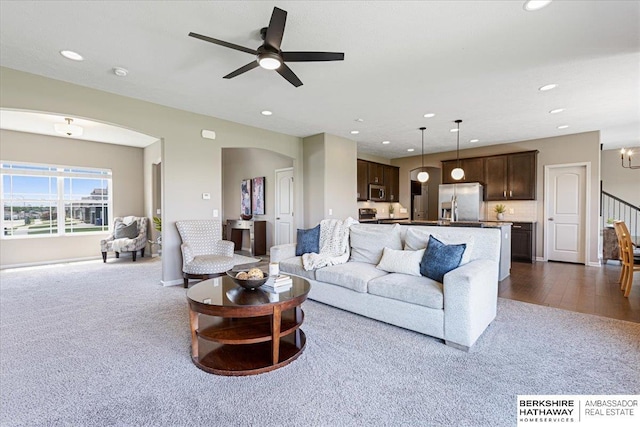 20904 Camden Ave, Omaha, NE 68022 - living area featuring dark colored carpet, arched walkways, recessed lighting, ceiling fan, and baseboards