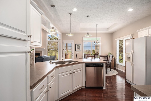 7409 N 160th St, Bennington, NE 68007 - kitchen featuring stainless steel dishwasher, white fridge with ice dispenser, a sink, a textured ceiling, and a peninsula