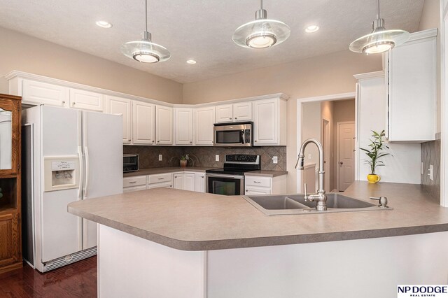 7409 N 160th St, Bennington, NE 68007 - kitchen with appliances with stainless steel finishes, a sink, dark wood-style floors, a peninsula, and white cabinets