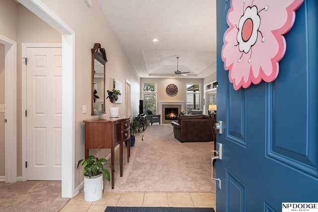 7409 N 160th St, Bennington, NE 68007 - entryway with light carpet, a lit fireplace, ceiling fan, light tile patterned flooring, and recessed lighting