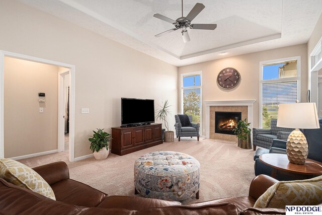 7409 N 160th St, Bennington, NE 68007 - living area featuring carpet, a fireplace, a tray ceiling, a ceiling fan, and baseboards