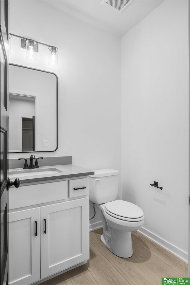 5409 N 196th Ave, Elkhorn, NE 68022 - bathroom with wood finished floors, toilet, vanity, and baseboards