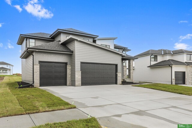 5409 N 196th Ave, Elkhorn, NE 68022 - view of front of house with a garage, a shingled roof, a front yard, concrete driveway, and stone siding