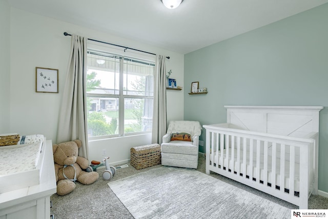 2206 Alexandra Rd, Papillion, NE 68133 - carpeted bedroom featuring a crib and baseboards