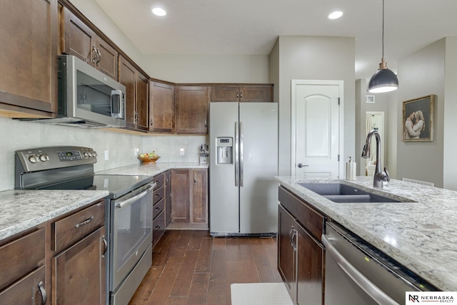 2206 Alexandra Rd, Papillion, NE 68133 - kitchen featuring stainless steel appliances, a sink, dark wood-style flooring, hanging light fixtures, and tasteful backsplash