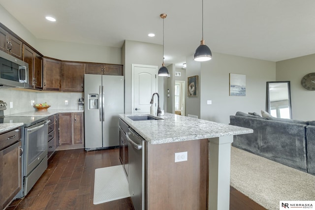 2206 Alexandra Rd, Papillion, NE 68133 - kitchen featuring appliances with stainless steel finishes, a sink, dark wood-style flooring, open floor plan, and light stone counters
