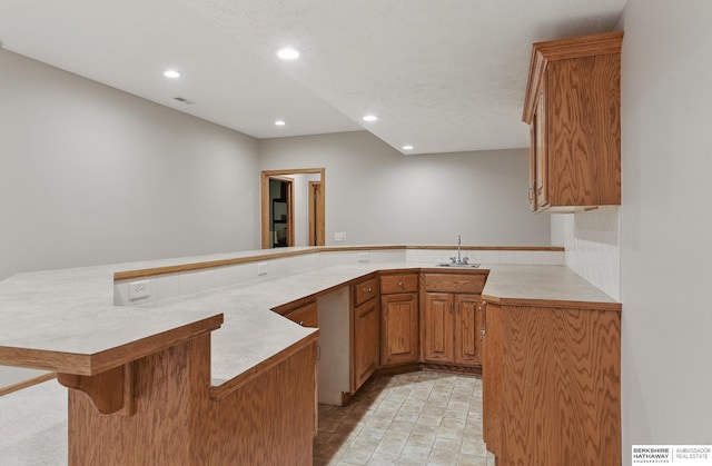 17616 Englewood St, Omaha, NE 68135 - kitchen featuring a sink, light countertops, a peninsula, recessed lighting, and a breakfast bar