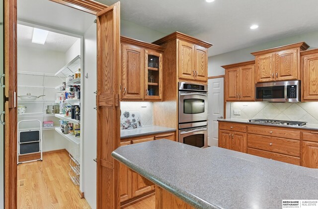 17616 Englewood St, Omaha, NE 68135 - kitchen with appliances with stainless steel finishes, light wood-type flooring, backsplash, glass insert cabinets, and recessed lighting