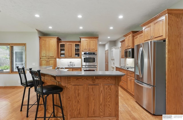17616 Englewood St, Omaha, NE 68135 - kitchen featuring appliances with stainless steel finishes, light wood-type flooring, recessed lighting, a breakfast bar, and a sink
