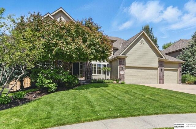 17616 Englewood St, Omaha, NE 68135 - view of front of home featuring brick siding, an attached garage, a front yard, driveway, and roof with shingles