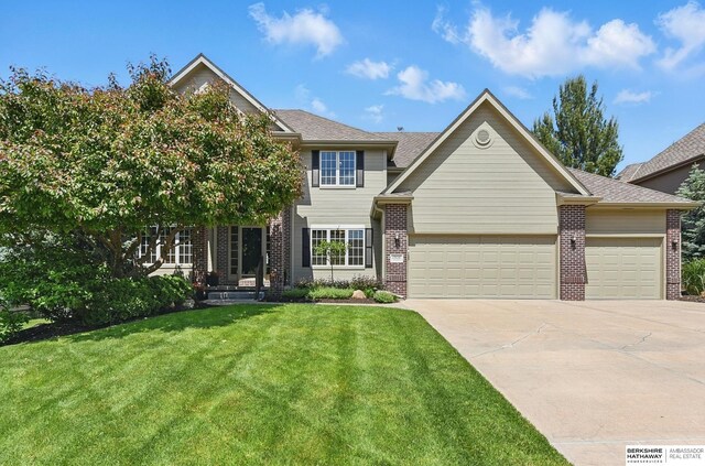 17616 Englewood St, Omaha, NE 68135 - view of front of home with brick siding, a garage, driveway, a front lawn, and roof with shingles