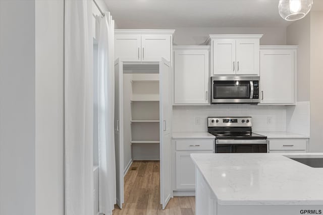 17312 Potter St, Bennington, NE 68005 - kitchen with appliances with stainless steel finishes, tasteful backsplash, white cabinets, and light wood-type flooring
