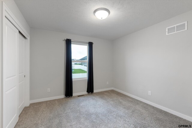 17312 Potter St, Bennington, NE 68005 - unfurnished bedroom featuring carpet, a closet, a textured ceiling, and baseboards