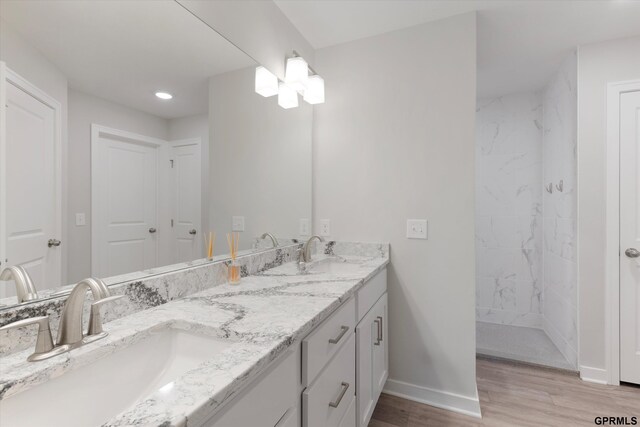 17312 Potter St, Bennington, NE 68005 - full bathroom featuring baseboards, wood finished floors, double vanity, a marble finish shower, and recessed lighting