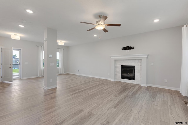 17312 Potter St, Bennington, NE 68005 - unfurnished living room with light wood-style floors, a ceiling fan, healthy amount of natural light, recessed lighting, and a glass covered fireplace