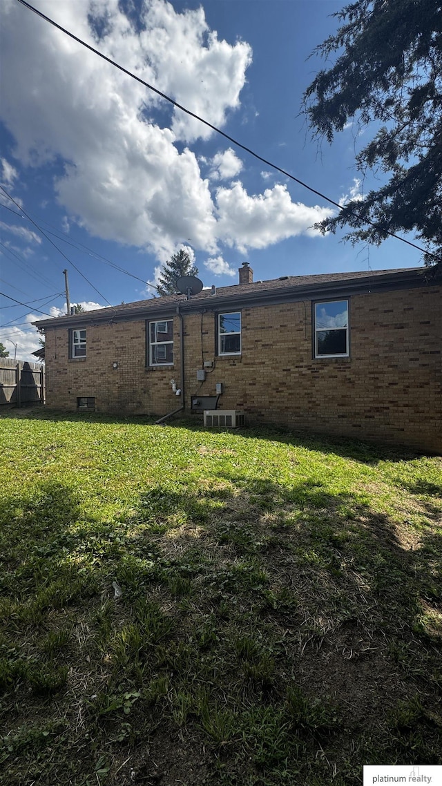 5218 Boyd St, Omaha, NE 68104 - back of property with brick siding, a yard, and a chimney