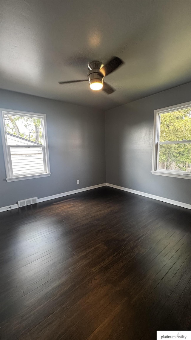5218 Boyd St, Omaha, NE 68104 - empty room with baseboards, healthy amount of natural light, dark wood finished floors, and ceiling fan