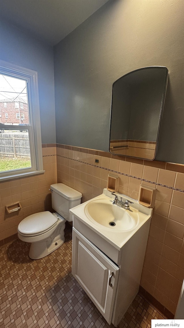 5218 Boyd St, Omaha, NE 68104 - half bathroom with tile walls, toilet, vanity, and a wainscoted wall