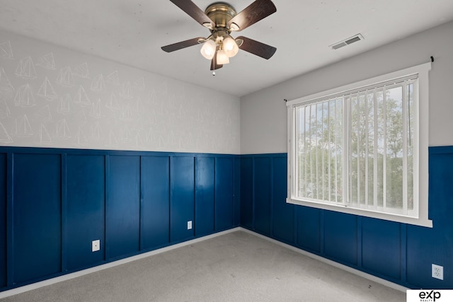 3003 Sheridan Rd, Bellevue, NE 68123 - spare room featuring a decorative wall, carpet flooring, ceiling fan, and a wainscoted wall