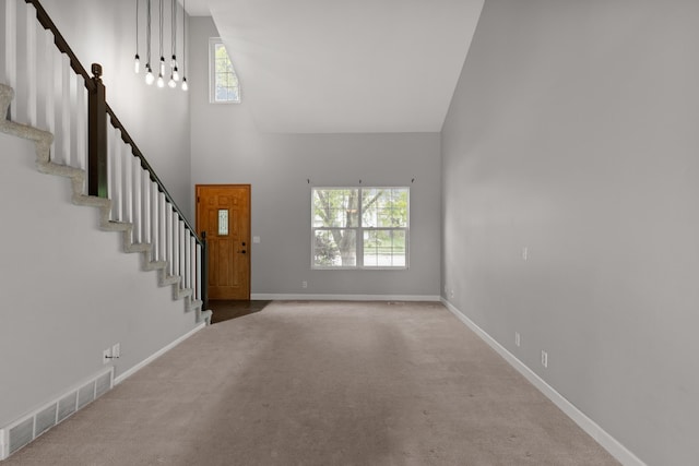 3003 Sheridan Rd, Bellevue, NE 68123 - unfurnished living room featuring high vaulted ceiling, healthy amount of natural light, stairway, carpet, and baseboards