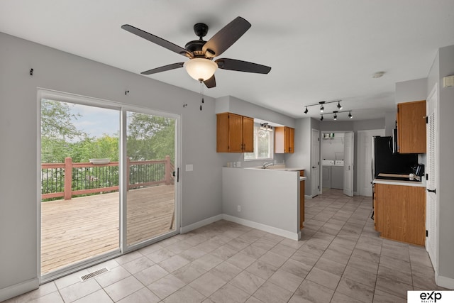 3003 Sheridan Rd, Bellevue, NE 68123 - kitchen featuring light countertops, brown cabinets, ceiling fan, independent washer and dryer, and baseboards