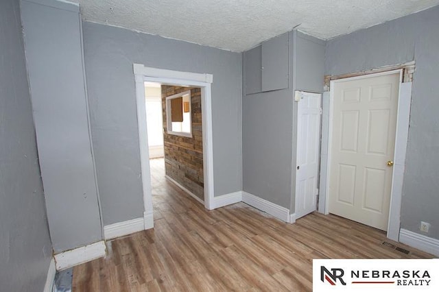 1801 Euclid Ave, Lincoln, NE 68502 - unfurnished bedroom featuring light wood-style floors, baseboards, a textured ceiling, and a closet