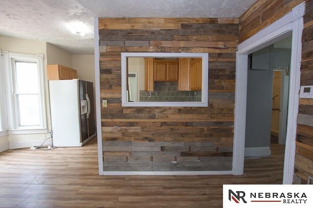 1801 Euclid Ave, Lincoln, NE 68502 - detailed view of white refrigerator with ice dispenser, a textured ceiling, wood finished floors, baseboards, and wood walls