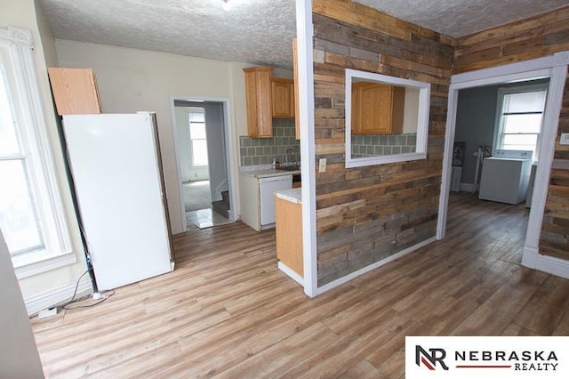 1801 Euclid Ave, Lincoln, NE 68502 - kitchen featuring white appliances, light countertops, light wood-type flooring, a textured ceiling, and washer / clothes dryer