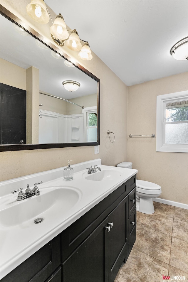 1305 S 4th Ave, Beatrice, NE 68310 - full bathroom with double vanity, toilet, tile patterned flooring, baseboards, and a shower