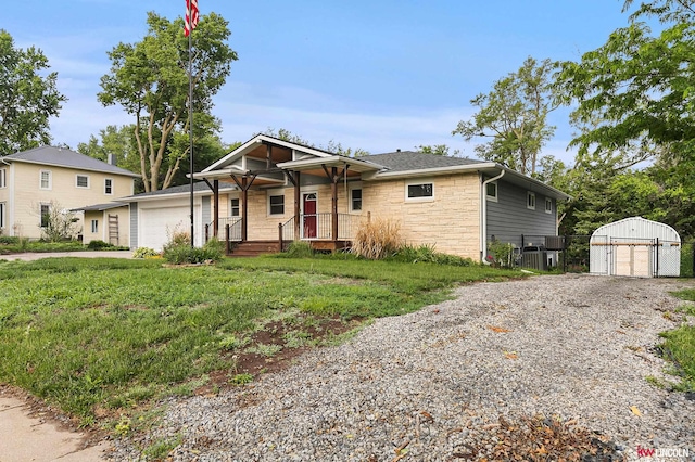 1305 S 4th Ave, Beatrice, NE 68310 - ranch-style home featuring stone siding, an outbuilding, a porch, central AC, and roof with shingles