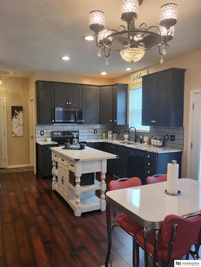 16228 Virginia St, Omaha, NE 68136 - kitchen featuring stainless steel microwave, electric range, a chandelier, a sink, and backsplash