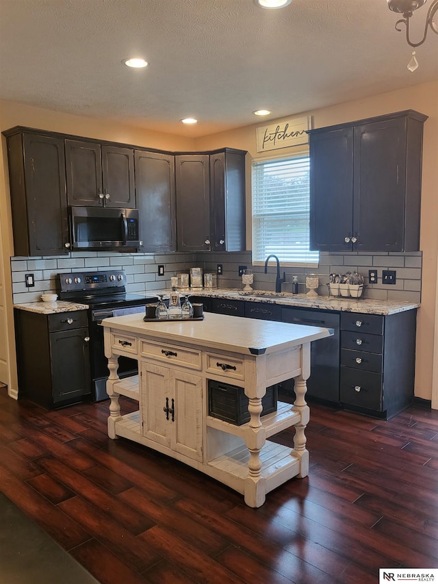 16228 Virginia St, Omaha, NE 68136 - kitchen featuring stainless steel microwave, black electric range oven, dark wood finished floors, tasteful backsplash, and recessed lighting