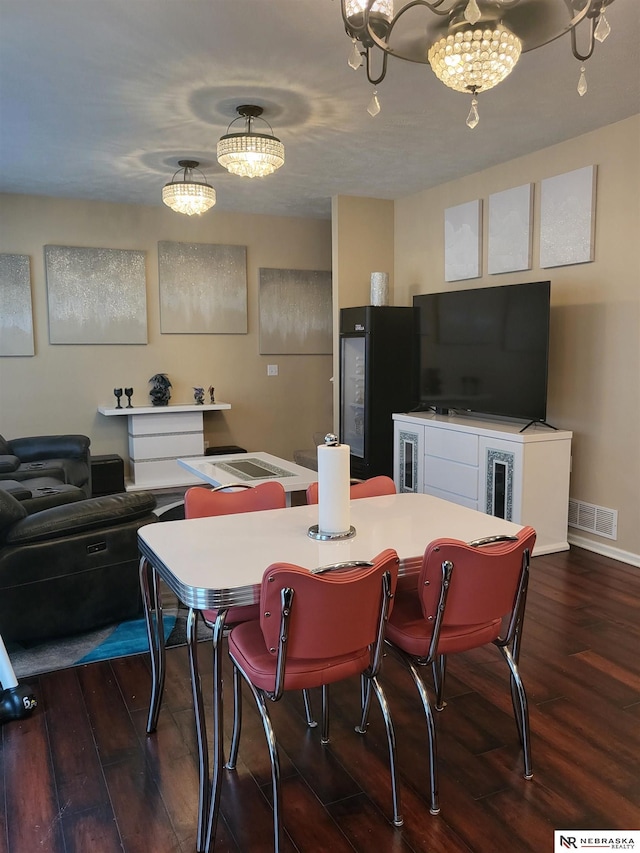 16228 Virginia St, Omaha, NE 68136 - dining area with dark wood-style flooring, a chandelier, and baseboards