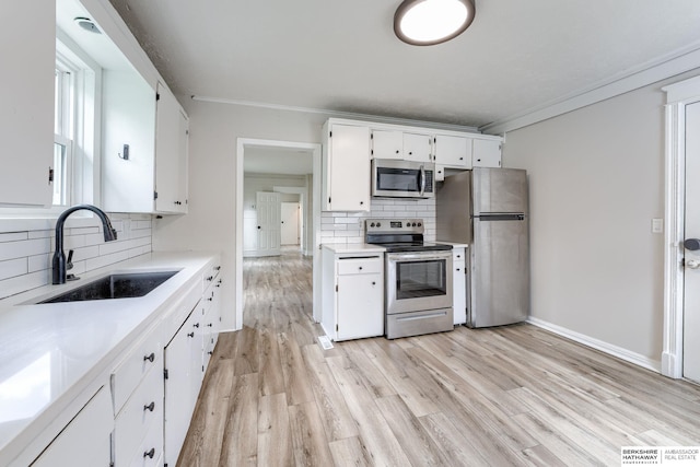 1943 Washington St, Blair, NE 68008 - kitchen featuring appliances with stainless steel finishes, a sink, tasteful backsplash, white cabinetry, and ornamental molding