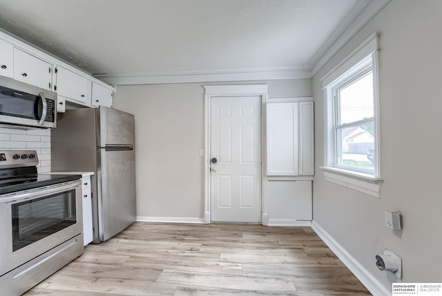 1943 Washington St, Blair, NE 68008 - kitchen with stainless steel appliances, white cabinetry, light wood-style flooring, tasteful backsplash, and baseboards