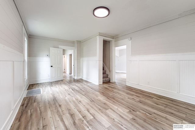 1943 Washington St, Blair, NE 68008 - spare room featuring stairway, light wood-style flooring, a decorative wall, and a wainscoted wall