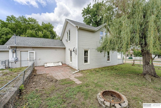 1943 Washington St, Blair, NE 68008 - rear view of house with a fire pit, a patio area, and roof with shingles
