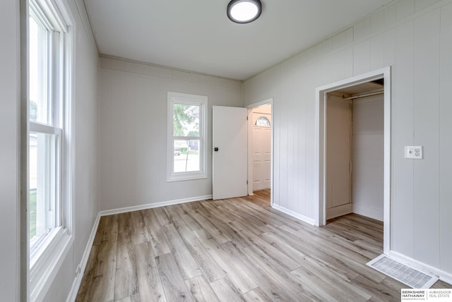 1943 Washington St, Blair, NE 68008 - unfurnished bedroom with light wood-type flooring, baseboards, a decorative wall, and a closet