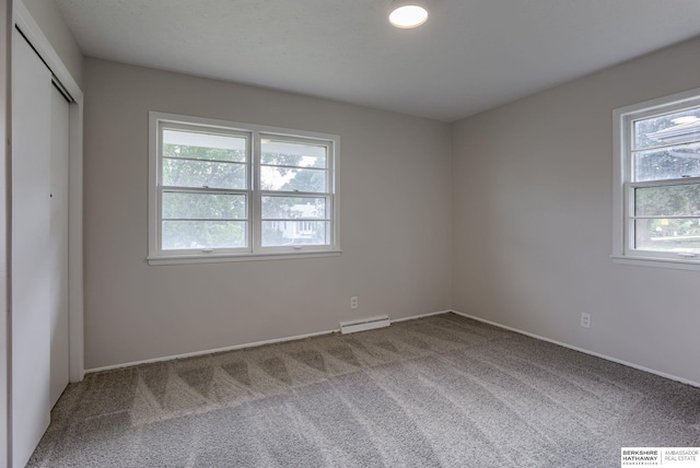 5002 S 77th Ave, Ralston, NE 68127 - unfurnished bedroom featuring carpet floors, multiple windows, and a baseboard radiator