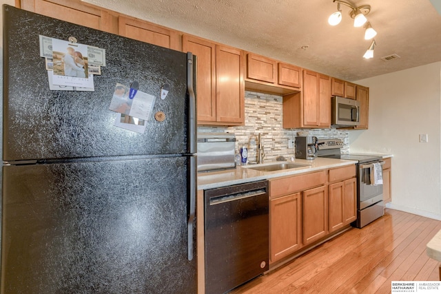 105 N 31st Ave Unit 502, Omaha, NE 68131 - kitchen featuring stainless steel appliances, a sink, light wood finished floors, tasteful backsplash, and light countertops
