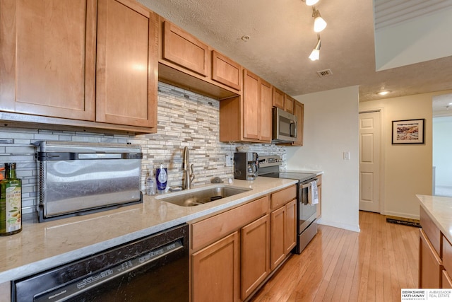 105 N 31st Ave Unit 502, Omaha, NE 68131 - kitchen featuring stainless steel appliances, a sink, tasteful backsplash, light wood-style flooring, and light stone countertops