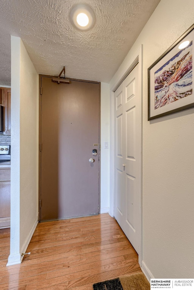 105 N 31st Ave Unit 502, Omaha, NE 68131 - corridor featuring light wood finished floors, a textured ceiling, and baseboards