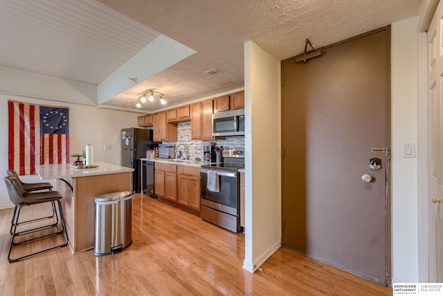 105 N 31st Ave Unit 502, Omaha, NE 68131 - kitchen with stainless steel appliances, light countertops, a breakfast bar area, tasteful backsplash, and a sink