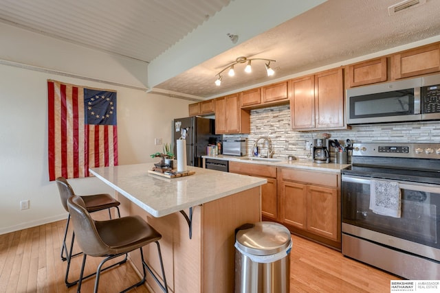 105 N 31st Ave Unit 502, Omaha, NE 68131 - kitchen featuring appliances with stainless steel finishes, a sink, decorative backsplash, and light countertops